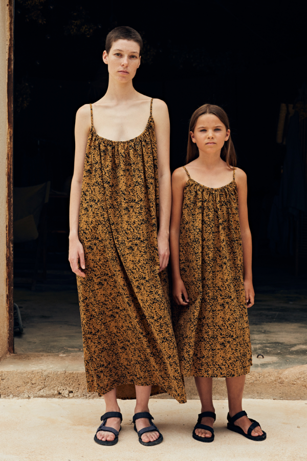 frontal view of kids model standing next to female model wearing the cala kids dress in amber color