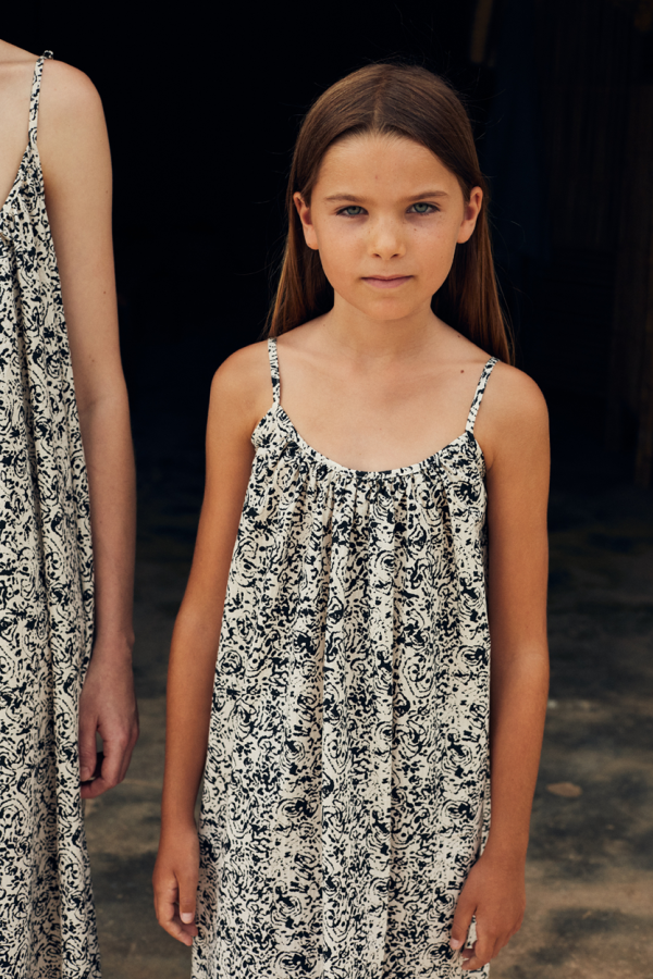 detailed front view of the kids model wearing the cala kids dress in avena color